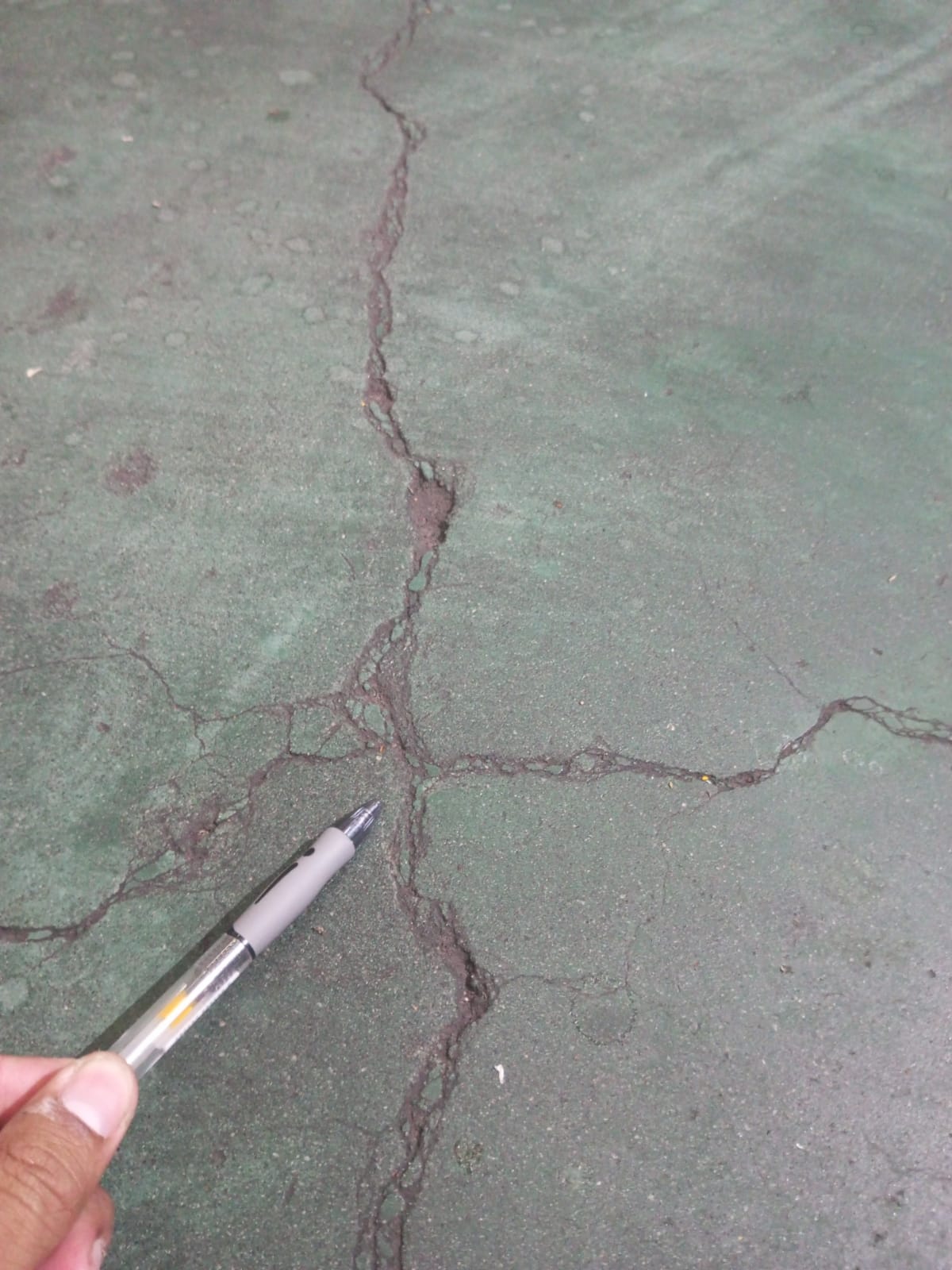 Retak menjalar seperti peta pada permukaan lantai beton berlapis coating