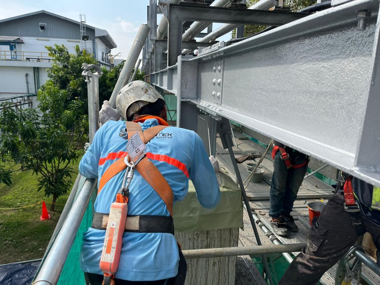 Pekerjaan coating balok baja eksterior dengan proteksi pada area sambungan baut