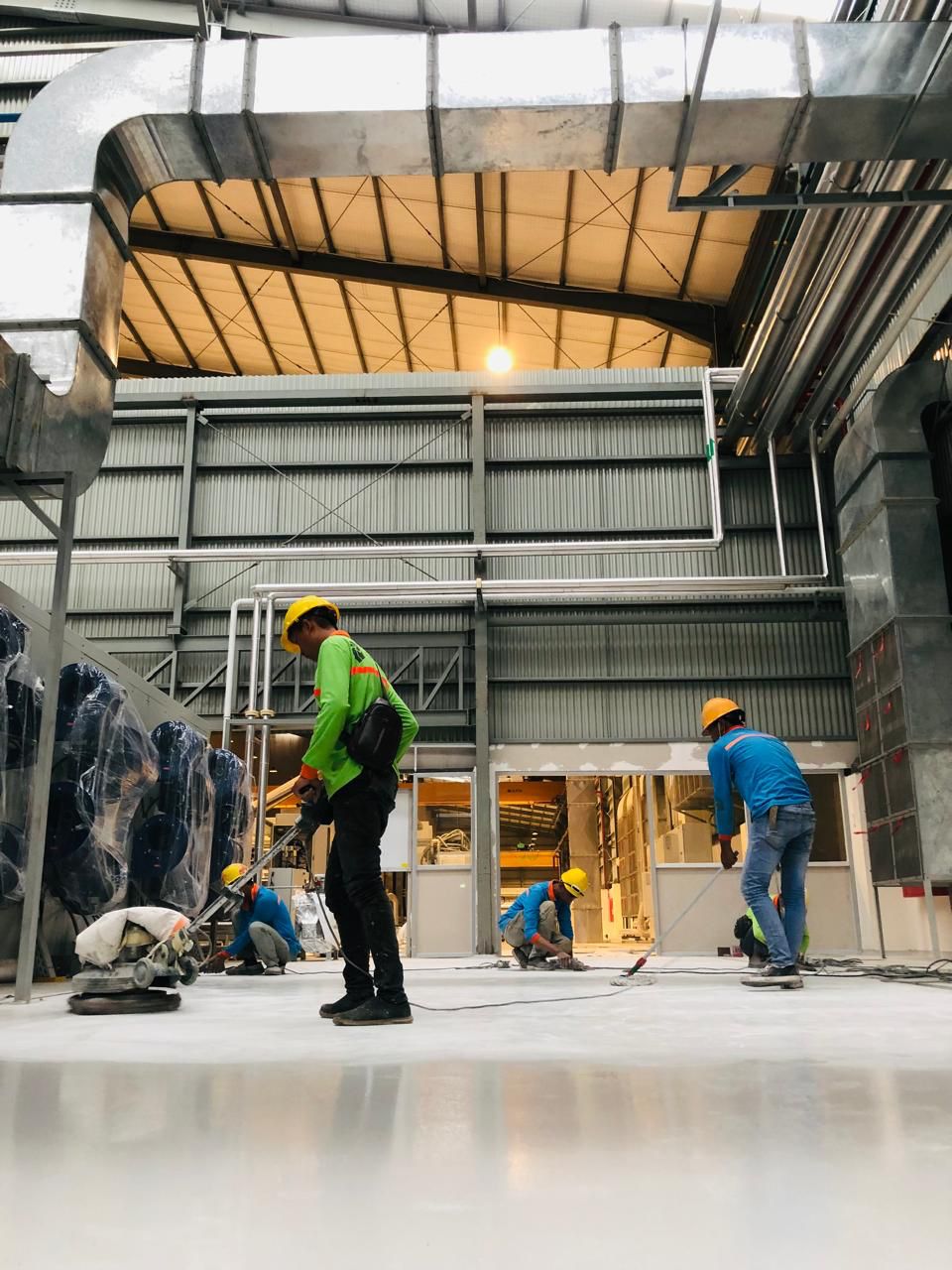 Tim Cakratek melakukan surface preparation dengan mesin grinding sebelum aplikasi epoxy flooring di area produksi