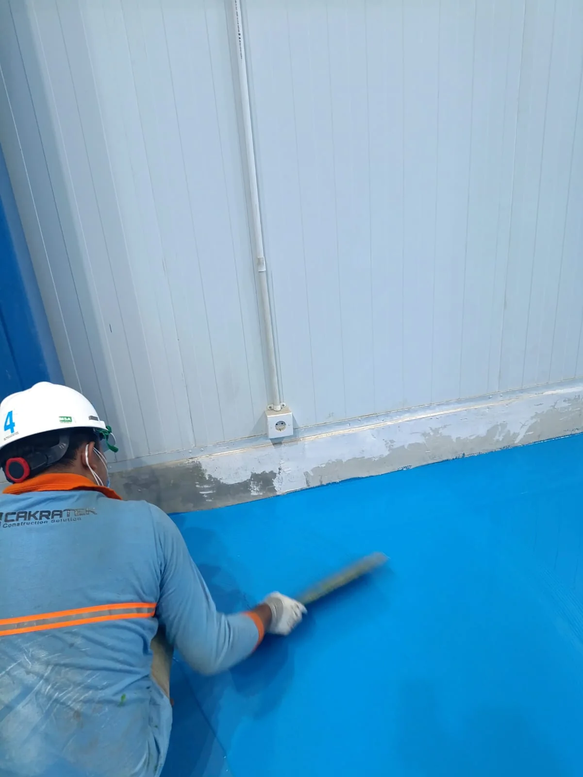 PU Concrete Flooring untuk Industri Dairy | Cakratek 5 Detail pekerja mengaplikasikan lapisan lantai di dekat dinding
