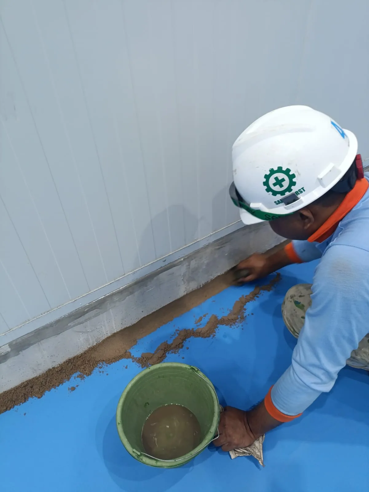 Pekerja Cakratek menyiapkan material pada pertemuan dinding dan lantai industri