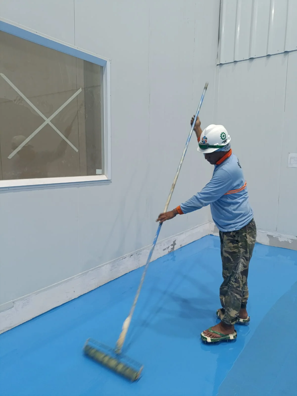 PU Concrete Flooring untuk Industri Dairy | Cakratek 6 Petugas memakai helm kerja dan melakukan aplikasi coating lantai industri