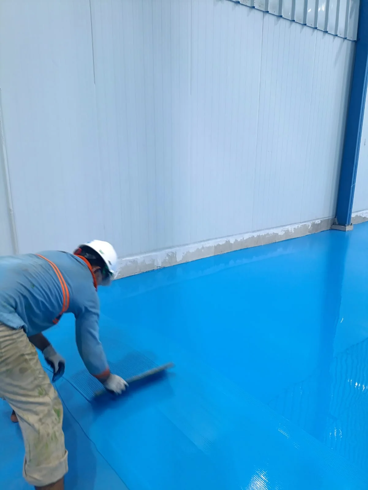 PU Concrete Flooring untuk Industri Dairy | Cakratek 4 Tim aplikasi meratakan lapisan lantai industri berwarna biru