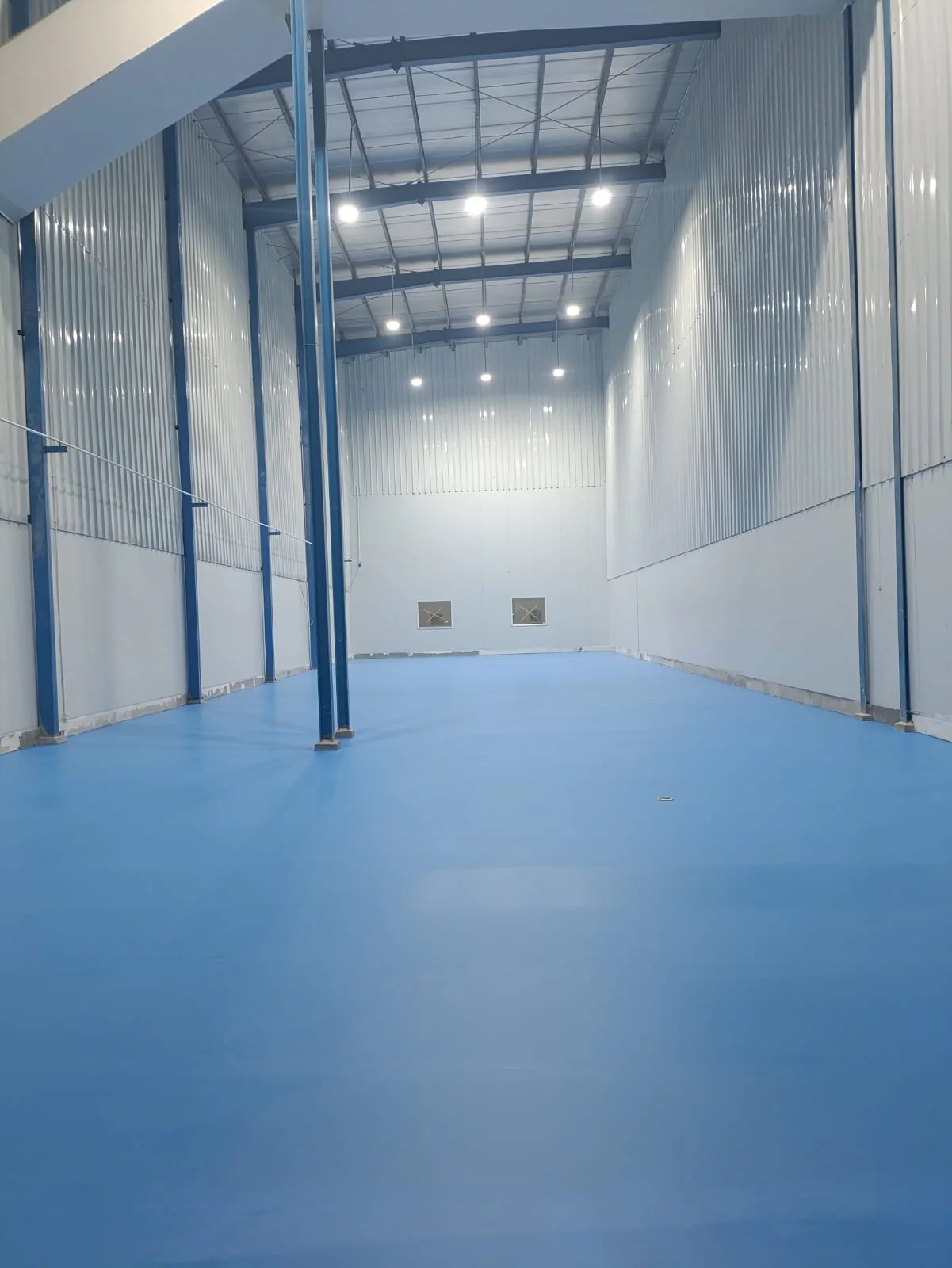 Dokumentasi area lantai industri dengan pelapisan warna biru oleh Cakratek