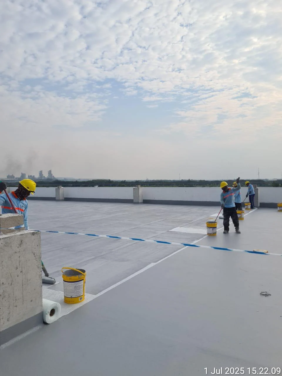 Tim lapangan melakukan aplikasi sistem pelapis waterproofing pada area atap industri